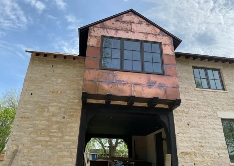 Copper metal panel facade on a stone building for Roof Repair in Navasota