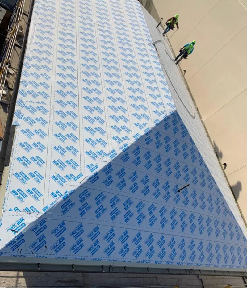 Professional roofers installing underlayment on a metal roof in Navasota